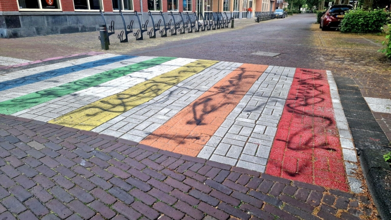 Nieuwe en oude regenboogzebrapad in Heiloo beklad met zwarte verf