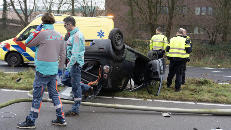 Auto op de kop na rammen lantaarnpaal Martin Luther Kingweg