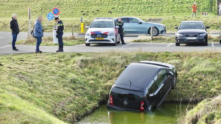 Vergeten handrem aan te trekken: auto en bestuurder belanden in het water