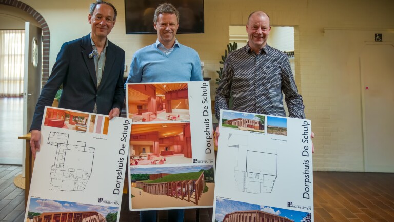 Drie mannen poseren binnen met ontwerptekeningen van Dorpshuis De Schulp.