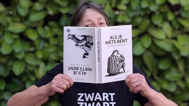 Persoon leest het boek "Als je niets bent" door Marjan Gerrits voor een groene achtergrond.