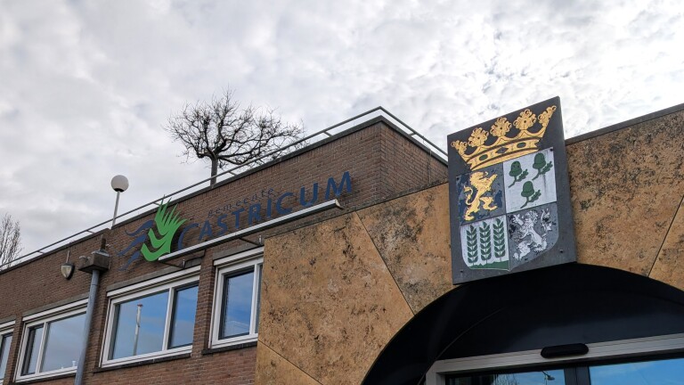 Gebouw met het logo van de gemeente Castricum en een wapenschild naast een ingang.