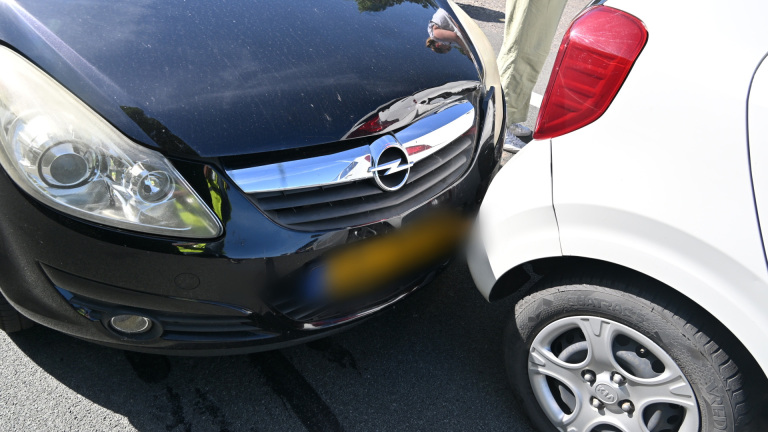 Twee auto's met lichte schade stonden met hun voor- en achterkant tegen elkaar aan.