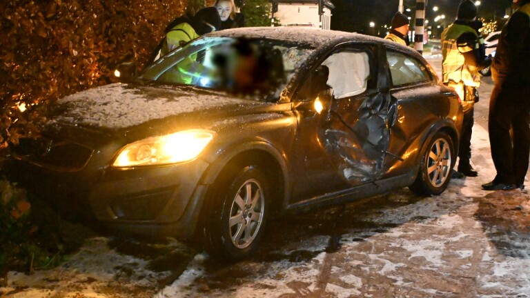 Bus naar Alkmaar Station met Connexxion-logo geparkeerd bij een huis 's avonds, met mensen op de stoep.
