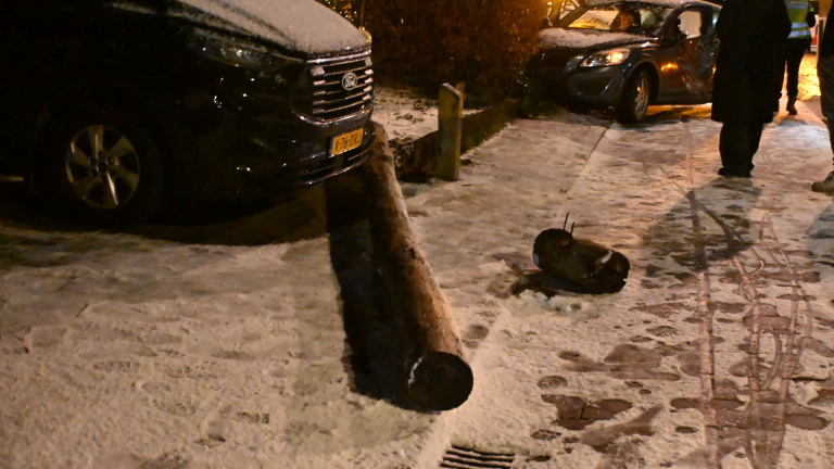 Bus naar Alkmaar Station met Connexxion-logo geparkeerd bij een huis 's avonds, met mensen op de stoep.