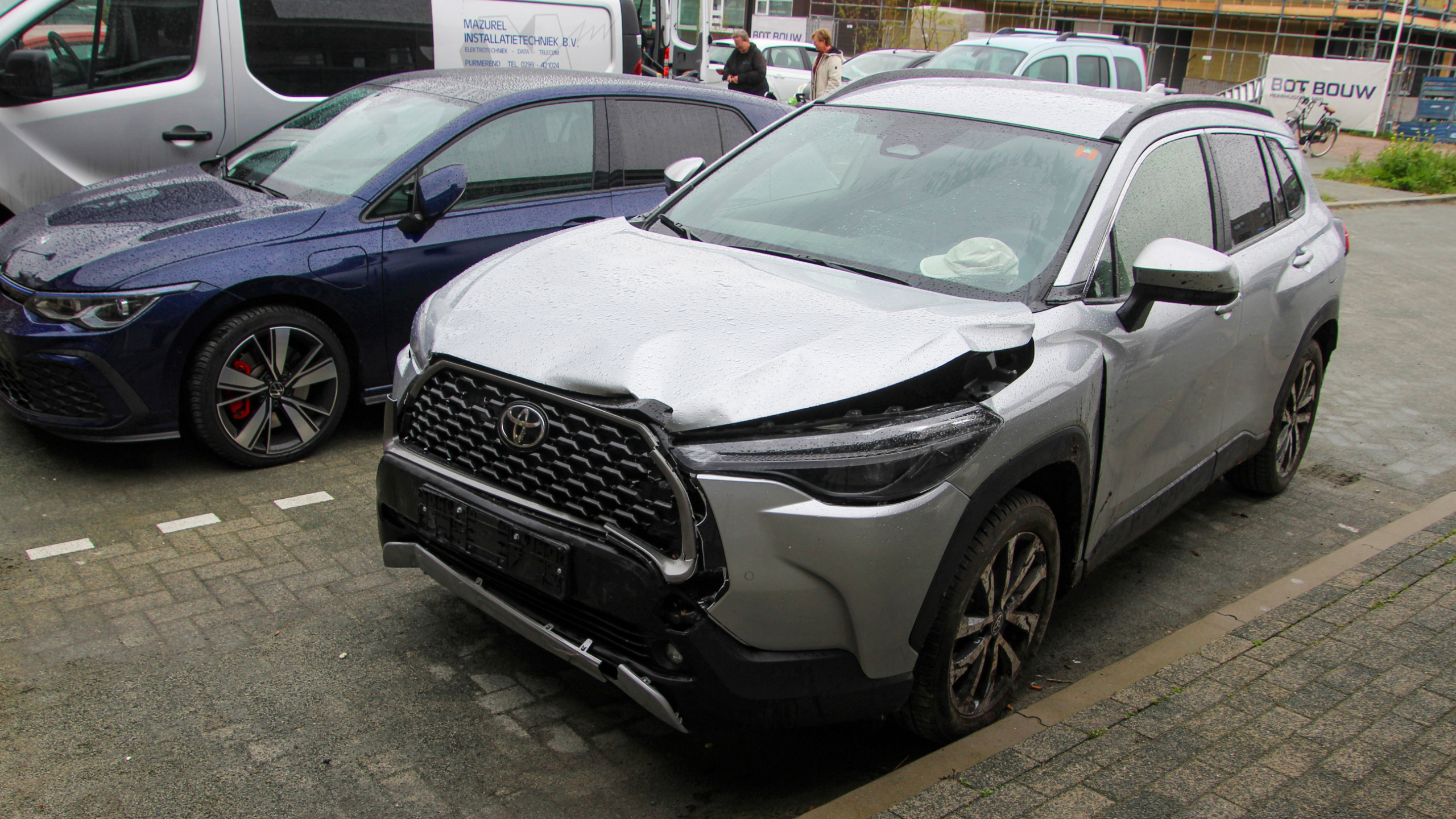 Fietsen geparkeerd naast een bakstenen muur met brievenbussen en een venster.